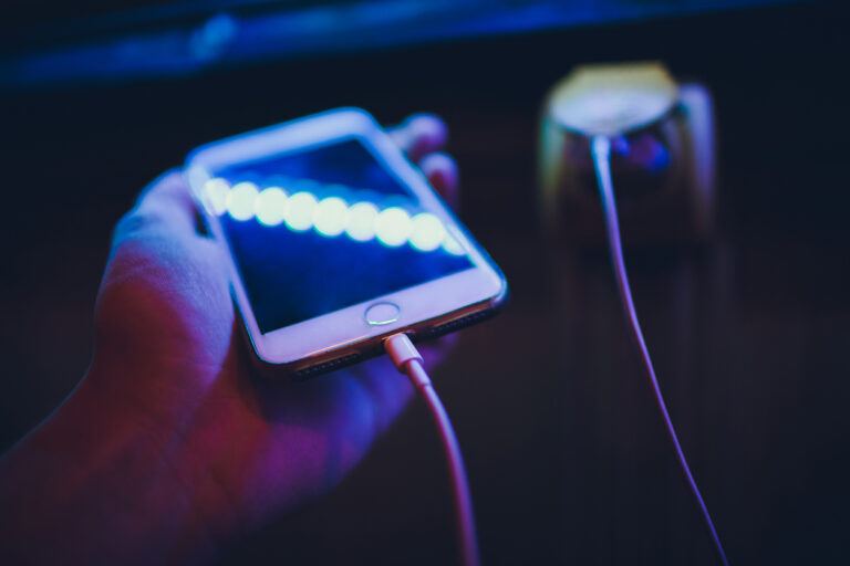 Hands of woman charging smartphone mobile phone device with cable and adapter